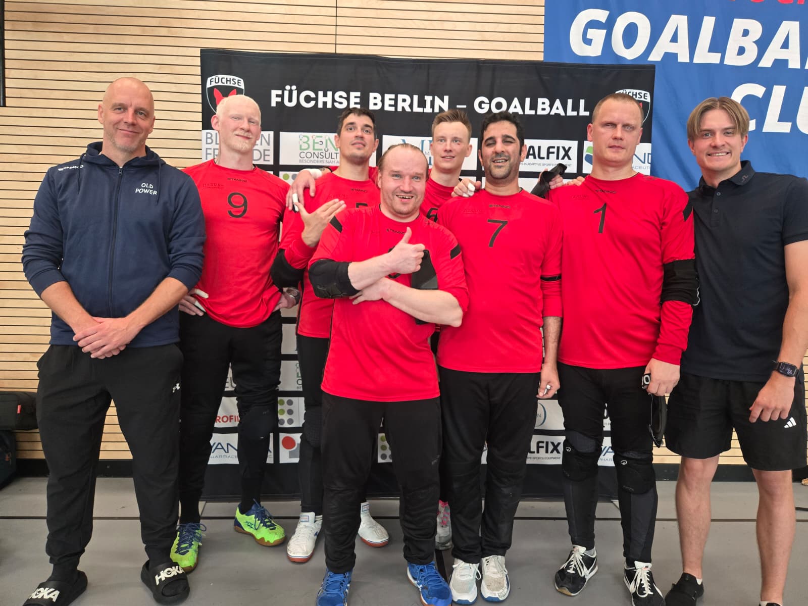 Old Powerin joukkue voitetun pronssiottelun jälkeen Füchse Sports Park-pelihallissa sponsoriseinämän edessä.