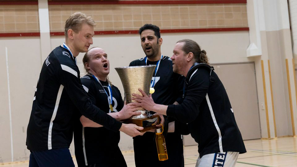 Old Powerin miespelaajat tuulettamassa iloisina mitalit kauloissaan, ja pokaali käsissään.