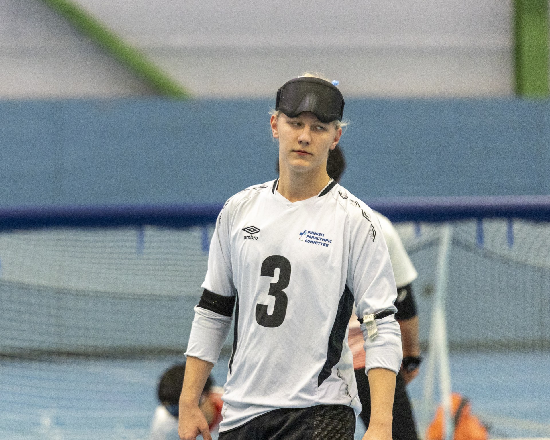 Utriainen lähikuvassa, kävelemässä pelikentällä maajoukkuepaidassa pelilasit nostettuna otsalle.