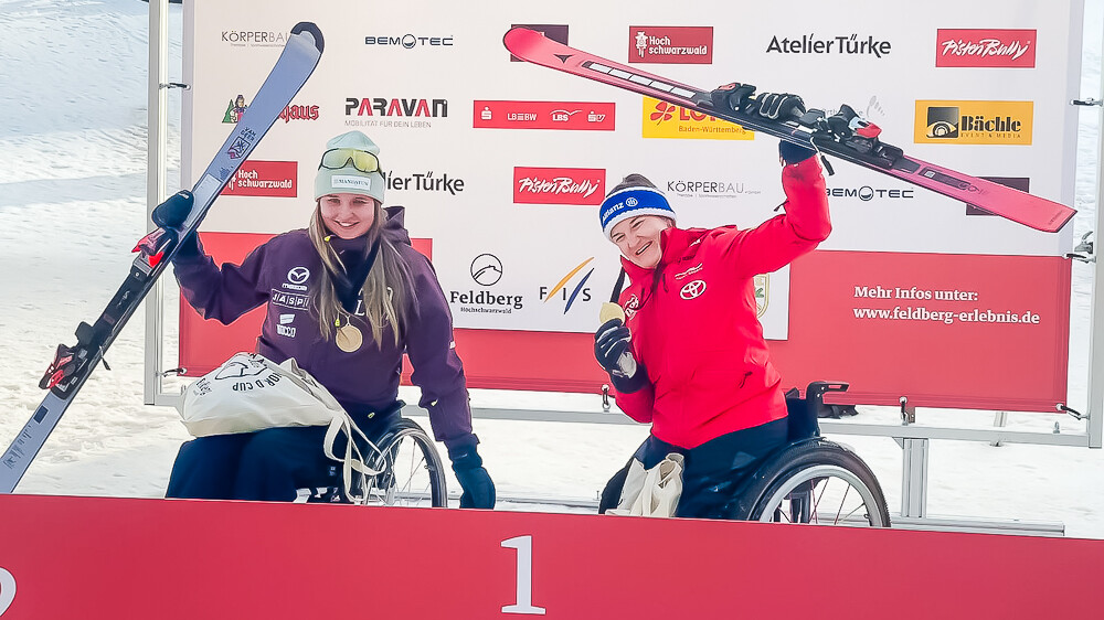 Nette Kiviranta tuulettamassa yhdessä kilpakumppaninsa kanssa suksi kädessään.