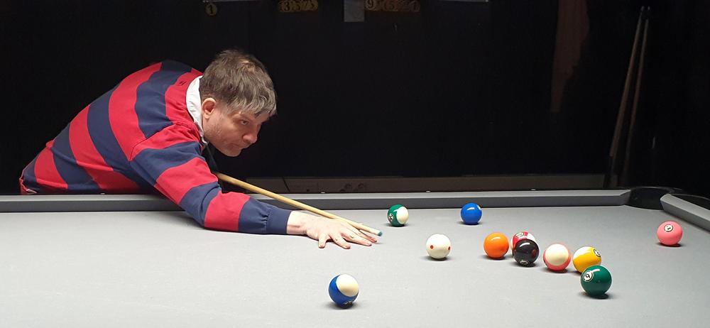 Tomas Hietanen pelaamassa biljardia keskittyneenä.