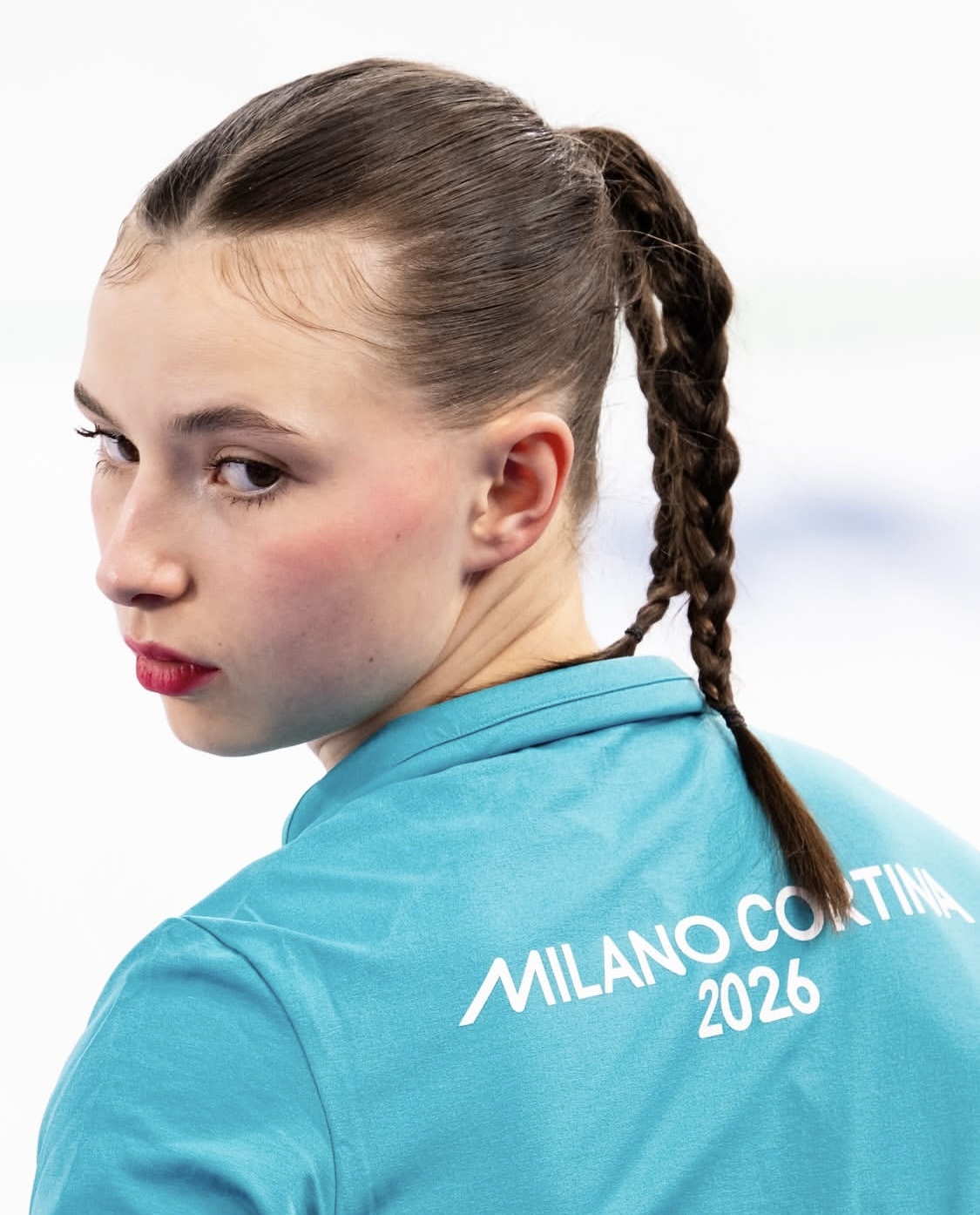 Kaisla Heikkinen kuvattuna takaa, pää kameraan päin käännettynä, päällä kisavarustus. Vakava ilme.