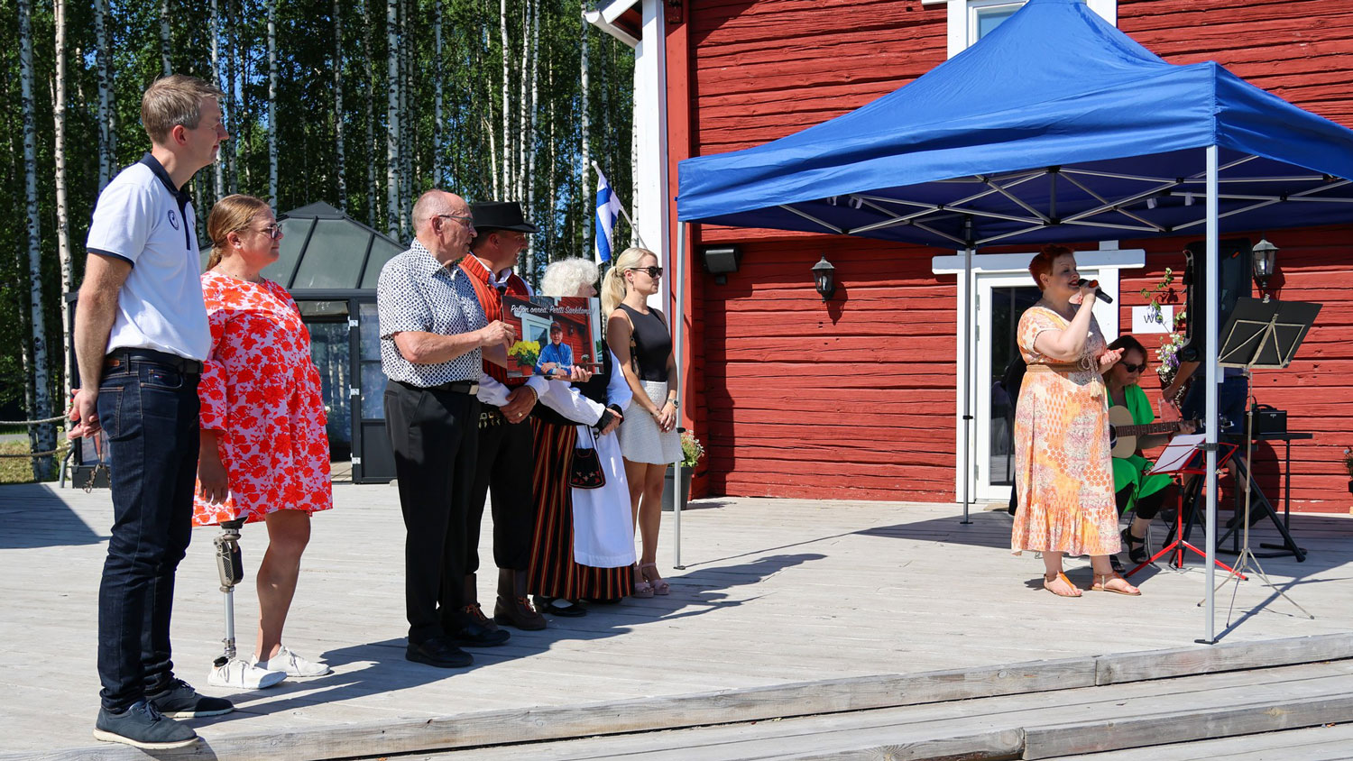 Sankilampi yhdessä vieraiden kanssa kuuntelemassa lauluesitystä.