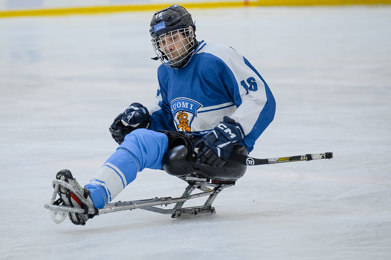 Jalka-amputoitu parajääkiekkoilija Suomen paidassa jäällä.