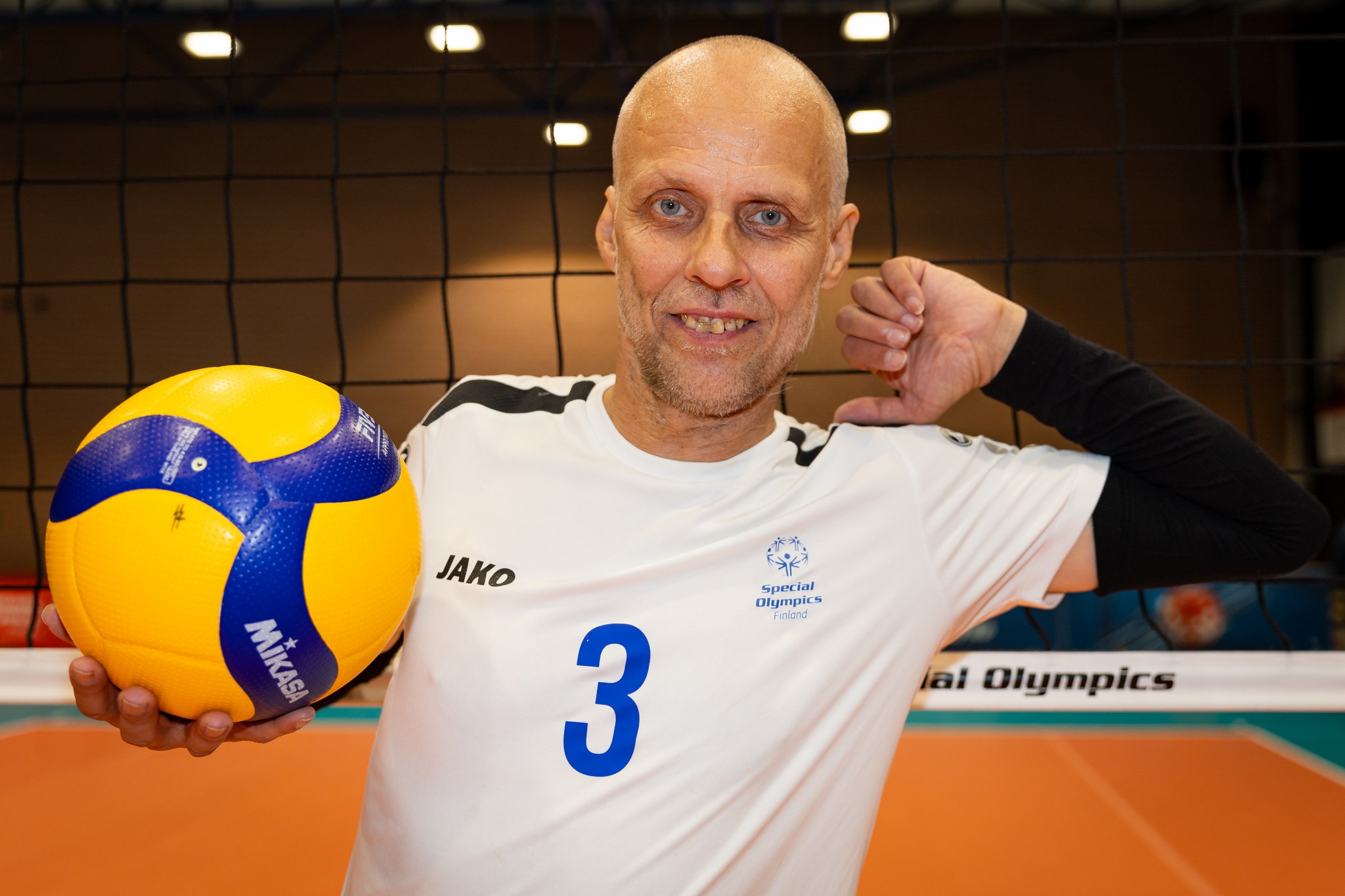 Mika Ahonen poseeraamassa kameralle lentopallon kanssa.