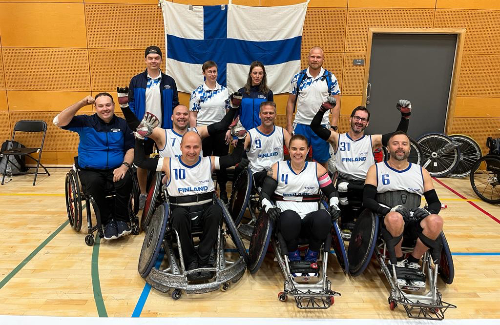 Suomen joukkue ryhmäkuvassa tuulettamassa iloisena.