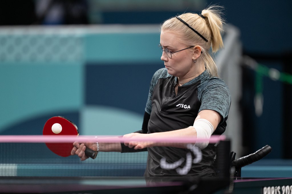 Aino Tapola pelaamassa pöytätennistä keskittyneenä Pariisin 2024 paralympialaisissa.