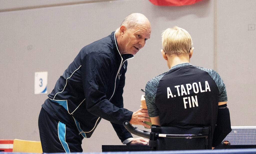 Martti Autio ja Aino Tapola. Autio tarjoamassa Tapolalle juotavaa pelien lomassa.
