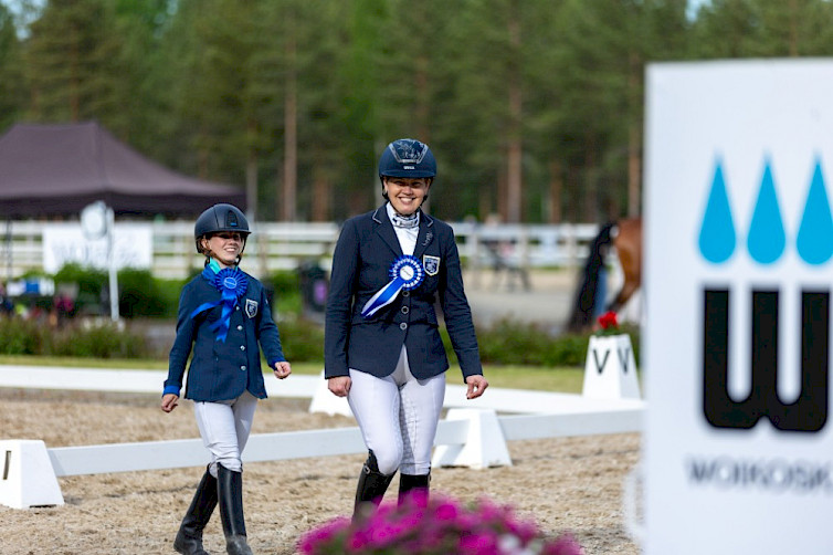 Jonna Aaltonen ja Jessica Kerttunen kävelemässä iloisena kisavarustuksessa palkittuina.