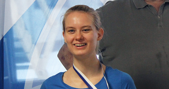Hanna Vilmi hymyilemässä mitali kaulassa.
