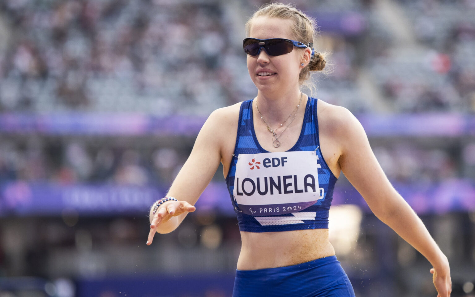 Iida Lounela kävelemässä hymyillen urheilusuorituksensa jälkeen. Kuva Pariisin 2024 paralympialaisista.
