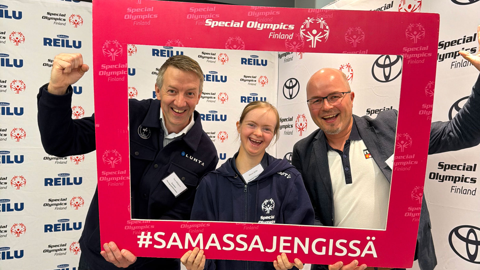 Timo Mäkynen, Wivan Atrila ja Markku Holmi iloisessa yhteiskuvassa #SamassaJengissä -kehyksen sisällä SO-lakanat taustalla.