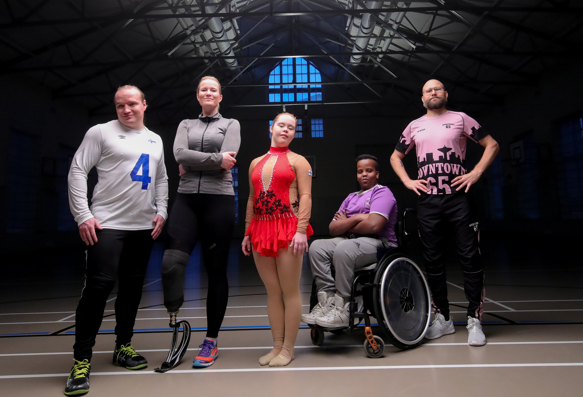 Eri vammaryhmien edustajia yhteiskuvassa liikuntahallissa.