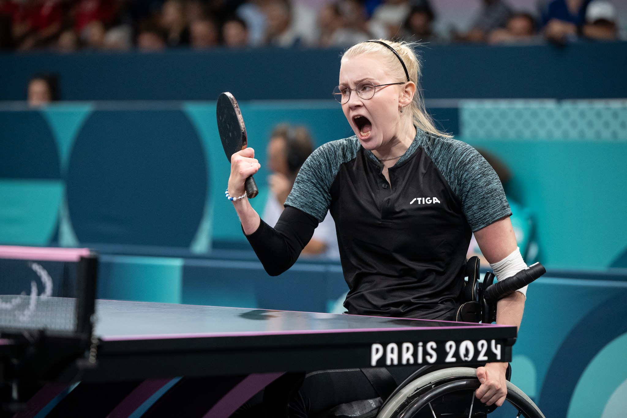 Aino Tapola Pariisin 2024 paralympialaisissa pelaamassa pöytätennistä kasvoillaan uhmakas ilme.