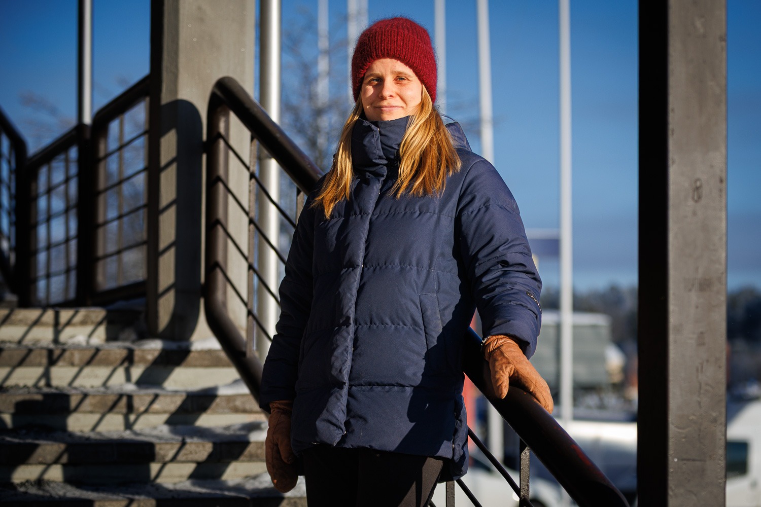 Pirjetta poseeraamassa kameralle auringonpaisteessa ulkona rappusissa.