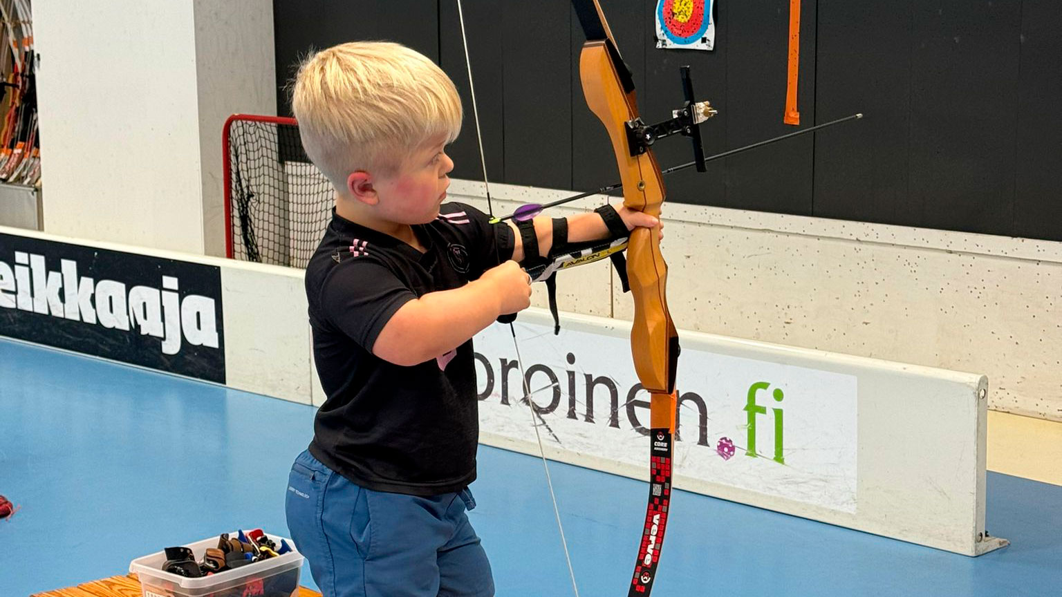 Onni keskittyneenä jousiampumassa.