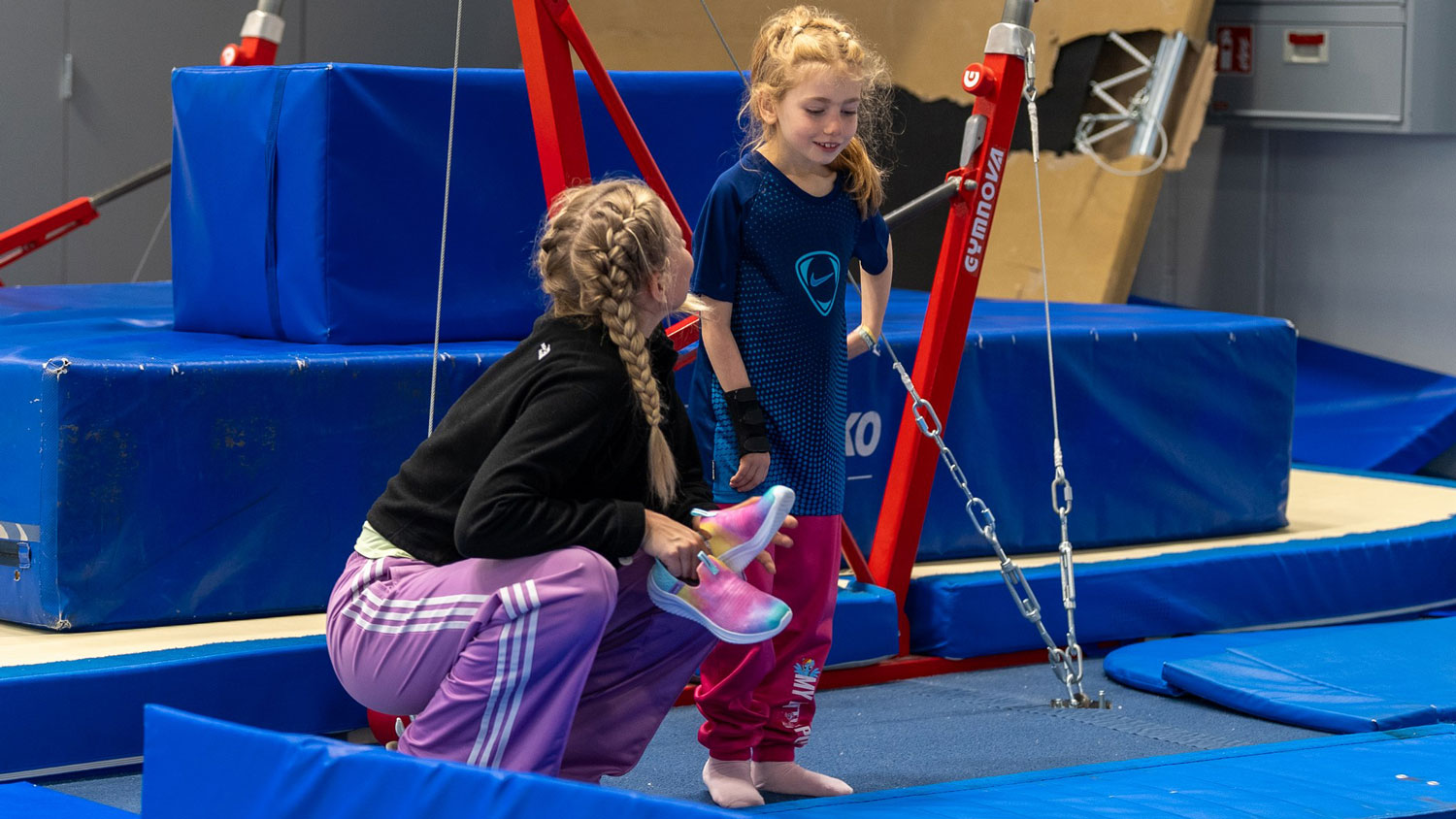 Naisoletettu Valtti ohjeistamassa tyttöoletettua harrastuskokeilussa trampoliinin vierellä.